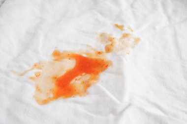 Kirli domates sosu lekesi ya da çamaşır tozuyla yıkamak için ketçap, ev işi konsepti..