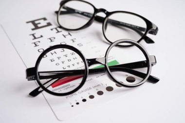 Görme yeteneğini ölçmek için göz muayenesi tablosundaki gözlüklerName.