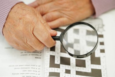 Bunama ve Alzheimer hastalıklarının tedavisi için sudoku bulmacası oynayan yaşlı kadın. 