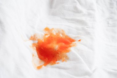 Kirli domates sosu lekesi ya da çamaşır tozuyla yıkamak için ketçap, ev işi konsepti..