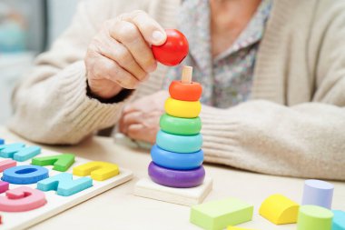 Asyalı yaşlı kadın bunama ve Alzheimer hastalıklarının tedavisi için bulmaca oyunu oynuyor.