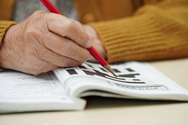 Bunama ve Alzheimer hastalıklarının tedavisi için sudoku bulmacası oynayan yaşlı kadın.