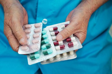 Asyalı yaşlı kadın elinde hap tutuyor, güçlü sağlıklı tıbbi konsept.. 