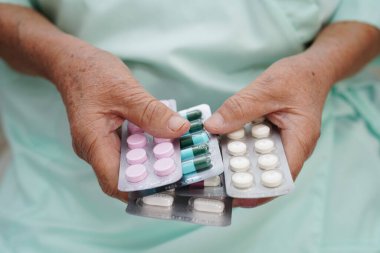 Asyalı yaşlı kadın elinde hap tutuyor, güçlü sağlıklı tıbbi konsept.. 