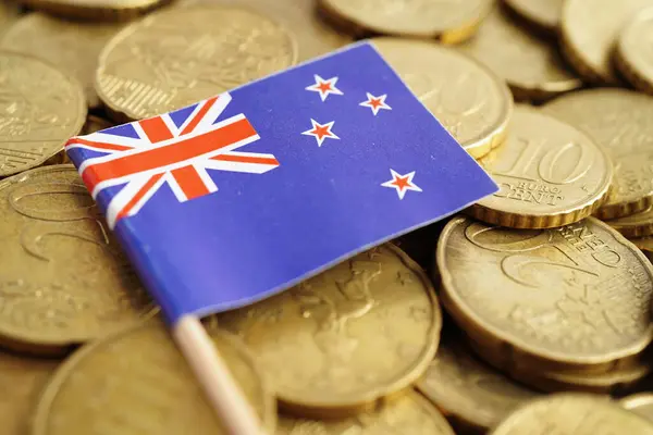 stock image New Zealand flag on coin and banknote money, finance trading investment business currency concept.