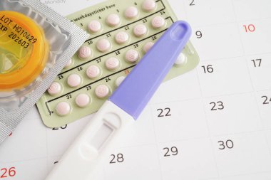 Doğum kontrol haplarıyla hamilelik testi ve takvimde kadınlar için prezervatif, yumurtlama günü.