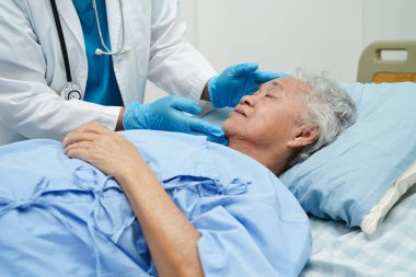 Klinikteki yaşlı kadın hastalarla ilgilenen, yardım eden ve onları cesaretlendiren doktor..