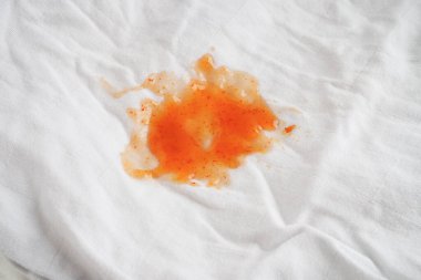 Kirli domates sosu lekesi ya da çamaşır tozuyla yıkamak için ketçap, ev işi konsepti..