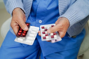 Asyalı yaşlı kadın elinde hap tutuyor, güçlü sağlıklı tıbbi konsept.. 