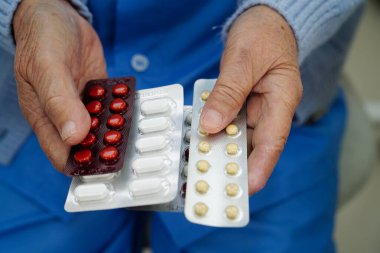 Asyalı yaşlı kadın elinde hap tutuyor, güçlü sağlıklı tıbbi konsept.. 