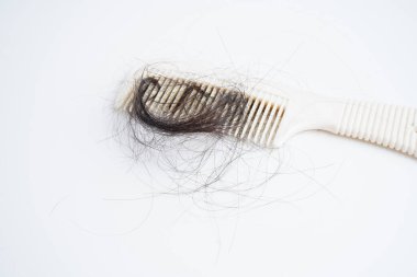 Tarak fırçasıyla beyaz arkaplanda saç kaybı.