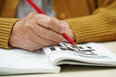 Asyalı yaşlı kadın bulmaca oyunu oynuyor.