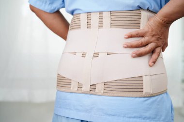 Esnek destek kemeri takan Asyalı son sınıf öğrencisi sırt ağrısını azaltabilir..