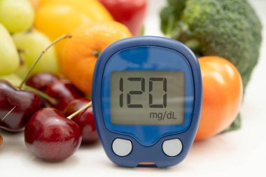 Şekerin şeker seviyesini kontrol etmek için sebze ve meyve içeren glikoz ölçer..