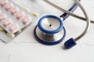 Stethoscope on electrocardiogram (ECG), heart wave, heart attack, cardiogram report.