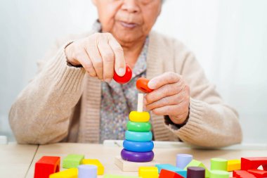 Asyalı yaşlı kadın oyun oynuyor.