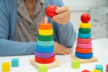 Asyalı yaşlı bir kadın, geliştirme oyunu oynuyor..