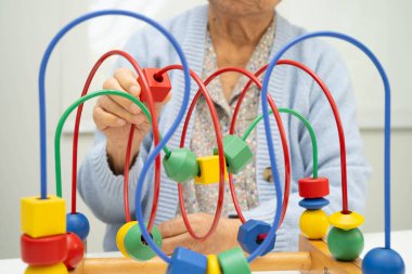 Asyalı yaşlı bir kadın, geliştirme oyunu oynuyor..