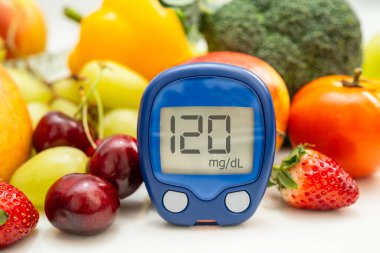 Şekerin şeker seviyesini kontrol etmek için sebze ve meyve içeren glikoz ölçer..