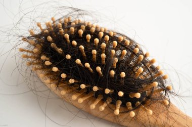 Tarak fırçasıyla beyaz arkaplanda saç kaybı.