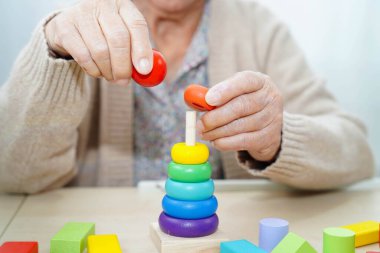 Asyalı yaşlı bir kadın, geliştirme oyunu oynuyor..