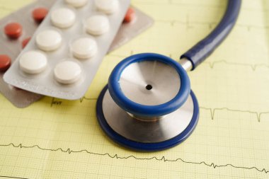 Elektrokardiyogramda stetoskop. Kapsül ilacı, kalp dalgası, kalp krizi, kardiyogram raporu..