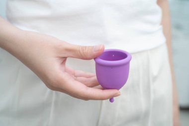 Hijyen dönemi koruması için elinde regl fincanı tutan Asyalı kadın..