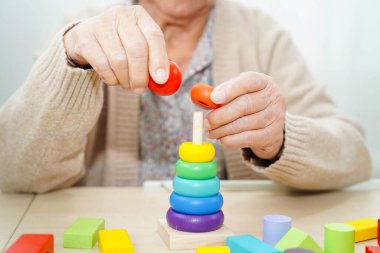 Asyalı yaşlı kadın oyun oynuyor.