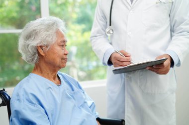 Klinikteki yaşlı kadın hastalarla ilgilenen, yardım eden ve onları cesaretlendiren doktor..