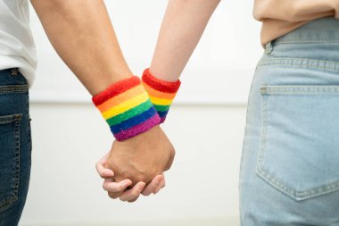 Gökkuşağı bilekliği takan Asyalı LGBT çifti..