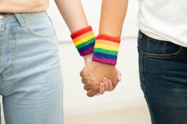 Gökkuşağı bilekliği takan Asyalı LGBT çifti..
