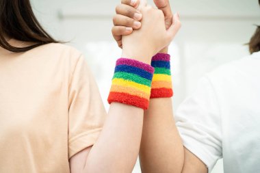 Gökkuşağı bilekliği takan Asyalı LGBT çifti..