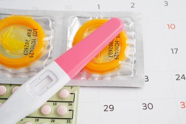 Doğum kontrol haplarıyla hamilelik testi ve takvimde kadınlar için prezervatif, yumurtlama günü.