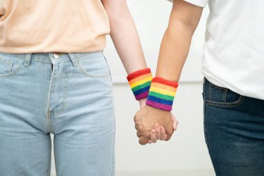 Gökkuşağı bilekliği takan Asyalı LGBT çifti..