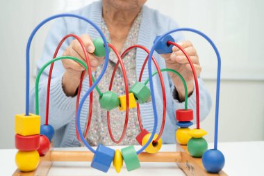 Asyalı yaşlı bir kadın, geliştirme oyunu oynuyor..