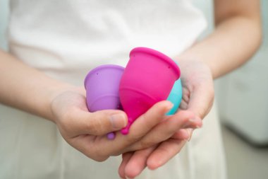 Hijyen dönemi koruması için elinde regl fincanı tutan Asyalı kadın..