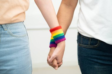Gökkuşağı bilekliği takan Asyalı LGBT çifti..