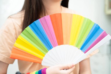 LGBT gökkuşağı bayrağı taşıyan Asyalı kadın.