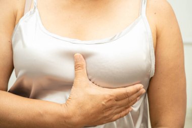 Asyalı kadın kendine dokunuyor çek şişliği ya da göğüs kanseri, göğüs muayenesi.