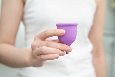 Hijyen dönemi koruması için elinde regl fincanı tutan Asyalı kadın..