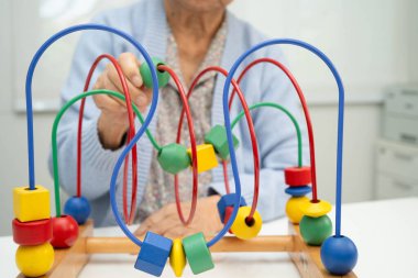 Asyalı yaşlı bir kadın, geliştirme oyunu oynuyor..