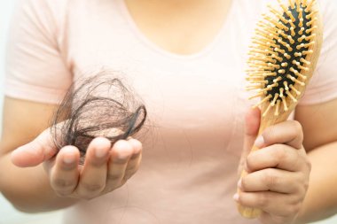 Asian woman have problem with long hair loss attach in her hand.