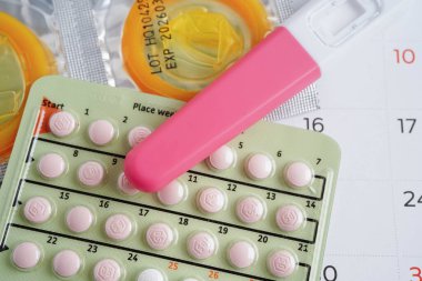 Doğum kontrol haplarıyla hamilelik testi ve takvimde kadınlar için prezervatif, yumurtlama günü.