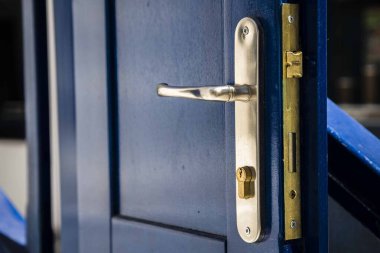 Bina kapısında mavi kilit olan metal kapı.