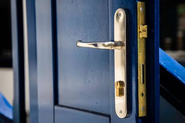 Bina kapısında mavi kilit olan metal kapı.