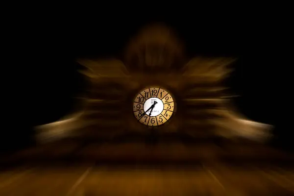 Koyu arkaplanda saati olan saat yüzü.