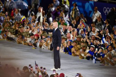 PARIS, FRANCE-26 Temmuz 2024: Eski futbolcu Zinedine Zidane, Paris 2024 Olimpiyat Oyunlarının açılış töreninde meşaleyi taşıdı