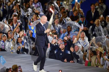 PARIS, FRANCE-26 Temmuz 2024: Eski futbolcu Zinedine Zidane, Paris 2024 Olimpiyat Oyunlarının açılış töreninde meşaleyi taşıdı