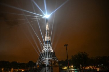 PARIS, FRANCE-26 July 2024: Lights illuminate the Eiffel Tower during the Opening Ceremony of the Olympic Games Paris 2024 clipart