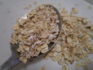 Bir yulaf lapası hazırlamak için tepeden tırnağa kaşık yulaf ezmesi..